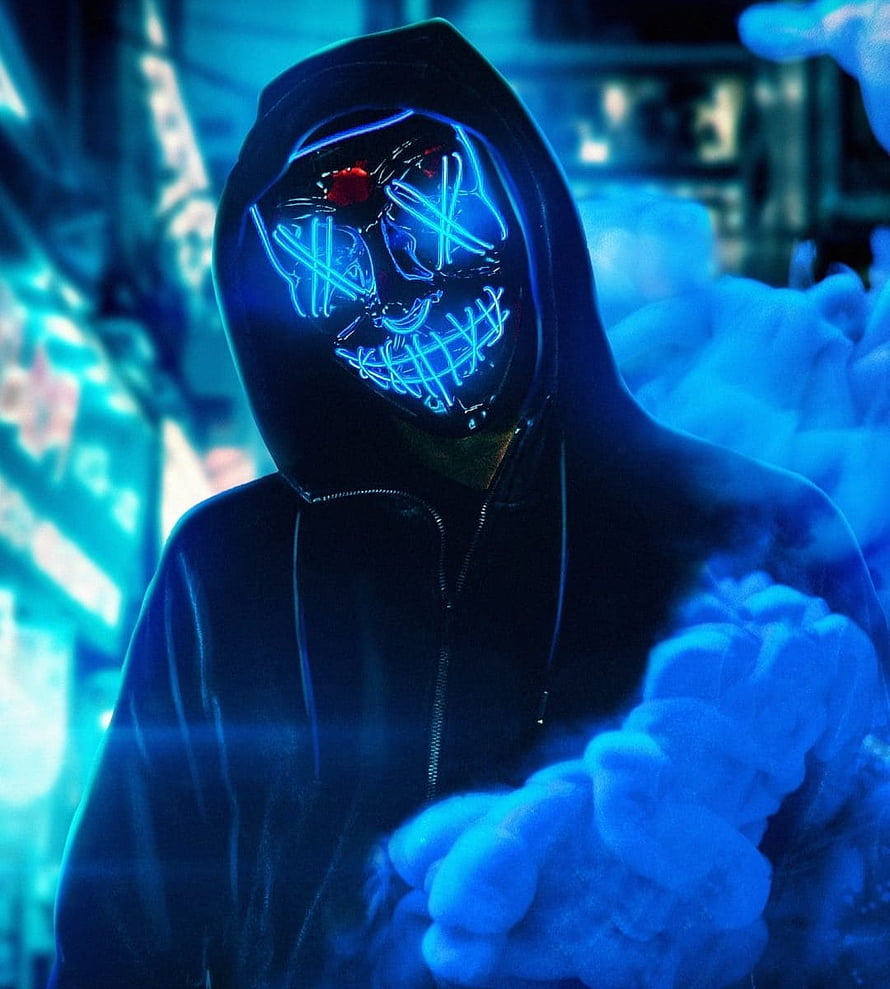 Mysterious Hooded Figure Wearing Glowing Neon Blue Skull Mask in Cyberpunk Atmosphere HD phone wallpaper