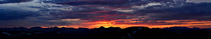 Dramatic Mountain Sunset Panorama with Fiery Orange Sky and Dark Silhouettes HD wallpaper