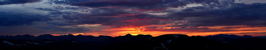 Dramatic Mountain Sunset Panorama with Fiery Orange Sky and Dark Silhouettes HD wallpaper