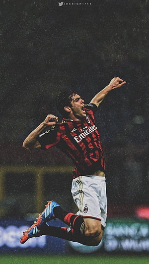Kaka in AC Milan kit leaping in celebration on a rainy night under stadium lights HD phone wallpaper