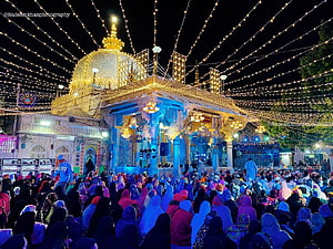 Ajmer Sharif Dargah illuminated at night with festive lights and a large gathering of devotees HD wallpaper