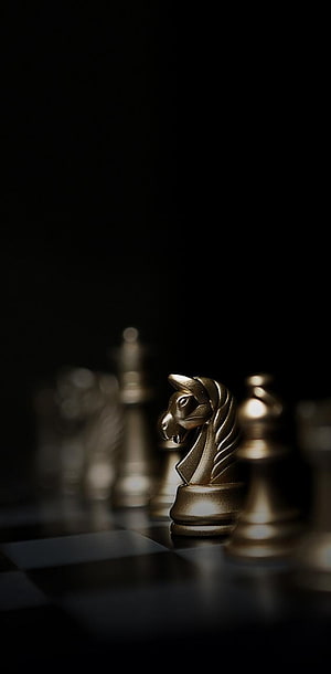 Golden Chess Knight on a Dark Board with Dramatic Lighting and Shallow Depth of Field HD phone wallpaper