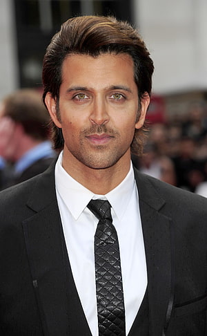 Hrithik Roshan in a black suit and textured tie at a formal red carpet event HD phone wallpaper