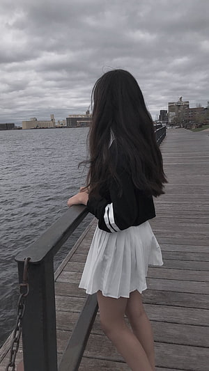 Girl in Black Jacket and White Skirt Standing on Wooden Pier by Water HD phone wallpaper