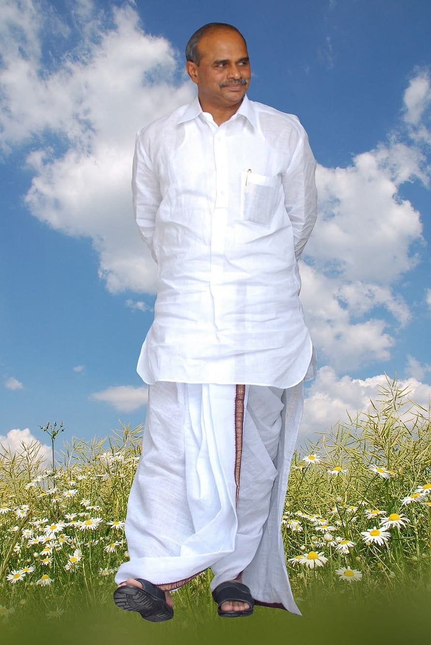 Dr. YSR in traditional white dhoti and shirt standing in a daisy field under a blue sky HD phone wallpaper