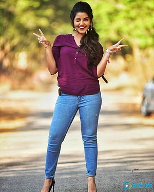 Anupama Parameswaran in purple top and blue jeans making peace signs outdoors HD phone wallpaper