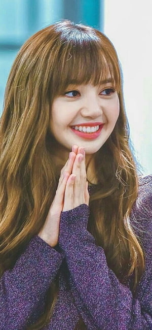 Lisa from Blackpink smiling with hands clasped in a purple sweater HD phone wallpaper