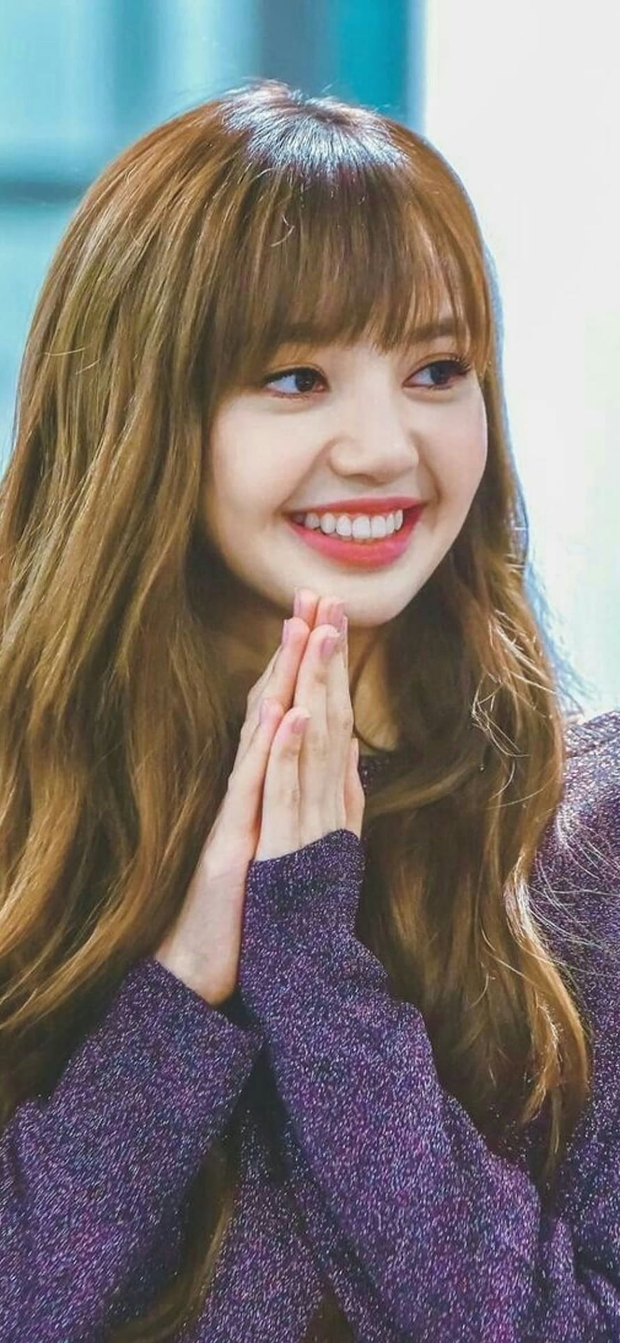 Lisa from Blackpink smiling with hands clasped in a purple sweater HD phone wallpaper