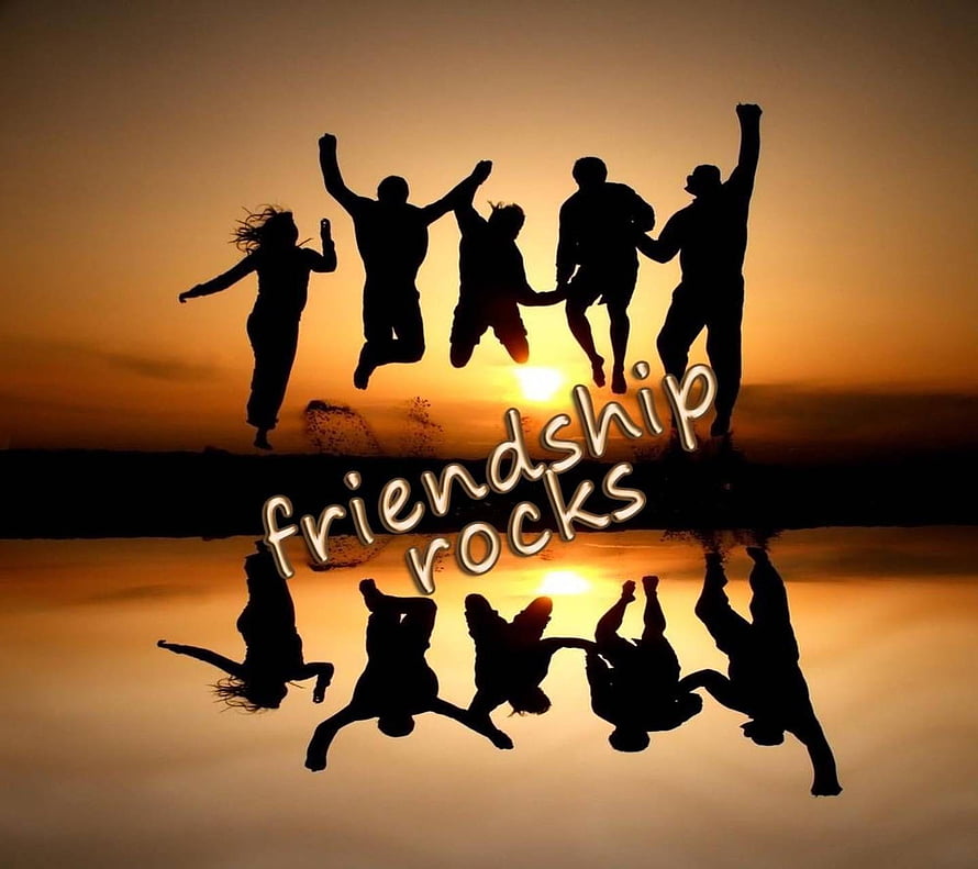 Silhouette of friends jumping in unison against a golden sunset with water reflection and friendship rocks text overlay HD wallpaper
