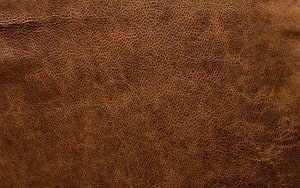 Close-Up Texture of Rich Brown Leather Surface with Natural Grain Patterns HD wallpaper