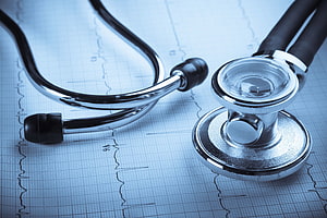 Stethoscope Resting on ECG Paper with Cardiac Waveforms in Cool Blue Tones HD wallpaper