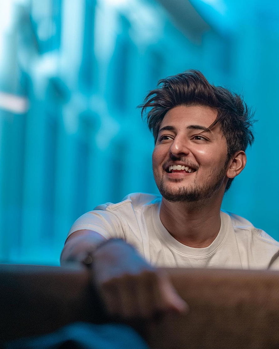 Darshan Raval Smiling Portrait Against Vibrant Blue Background HD phone wallpaper