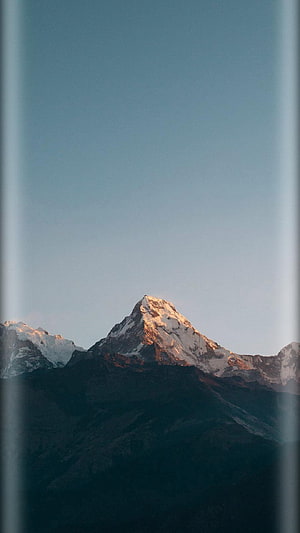 Majestic Snow-Capped Mountain Peak at Golden Hour with Clear Blue Sky HD phone wallpaper