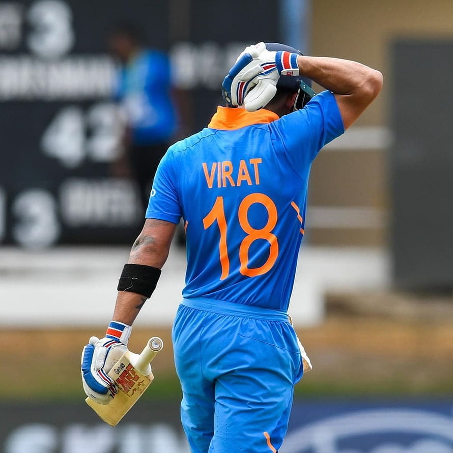 Virat Kohli in Blue Cricket Jersey Holding Bat and Adjusting Helmet HD phone wallpaper