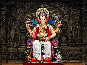 Lord Ganesha Statue with Axe and Lotus in Ornate Temple Setting HD wallpaper