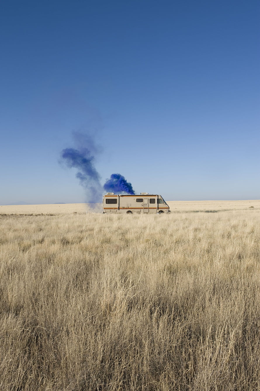 RV in a dry grassy field with blue smoke rising into a clear blue sky HD phone wallpaper