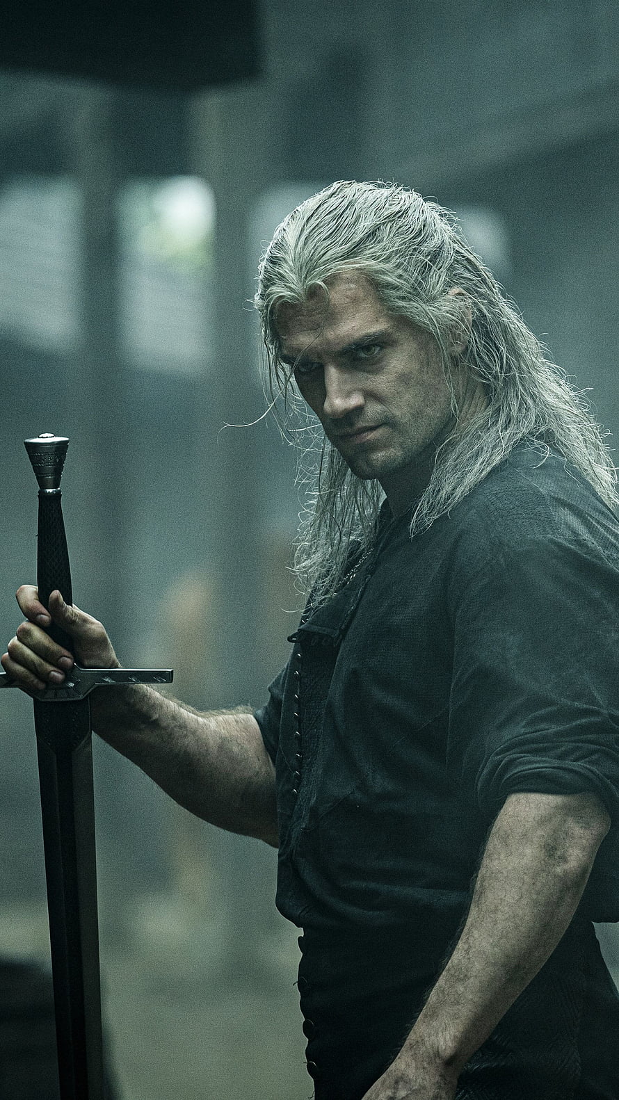 Geralt of Rivia from The Witcher holding a sword in a dark, moody setting HD phone wallpaper