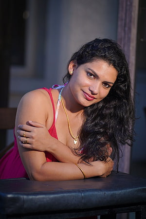 Resmi R Nair in a red dress with gold jewelry and long dark hair HD phone wallpaper