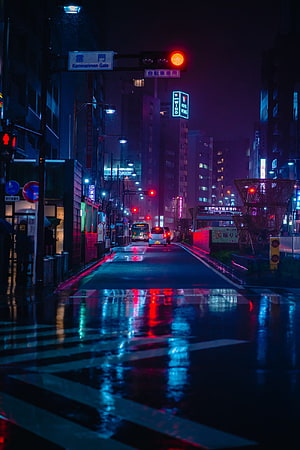 Neon-lit Tokyo street at night with wet pavement reflections and cyberpunk atmosphere HD phone wallpaper