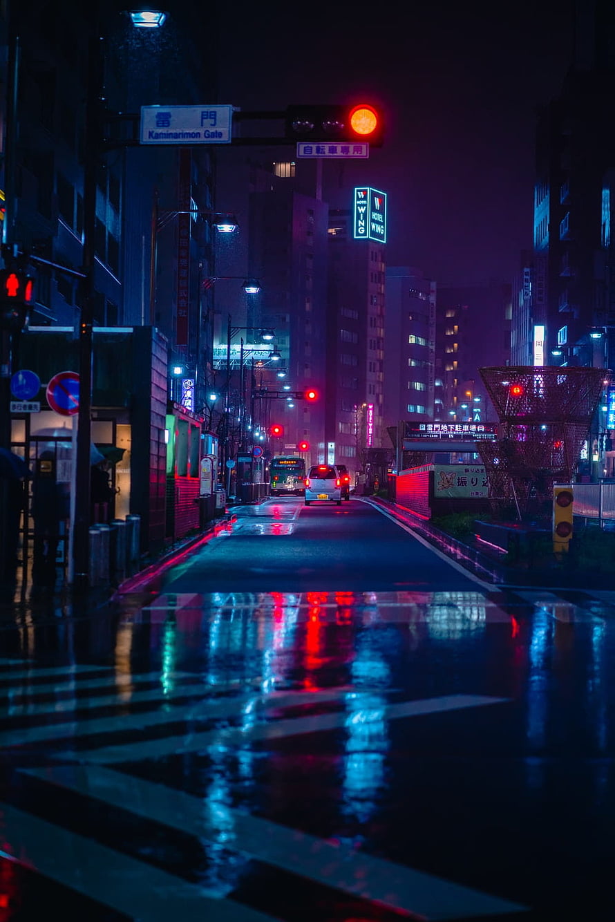 Neon-lit Tokyo street at night with wet pavement reflections and cyberpunk atmosphere HD phone wallpaper
