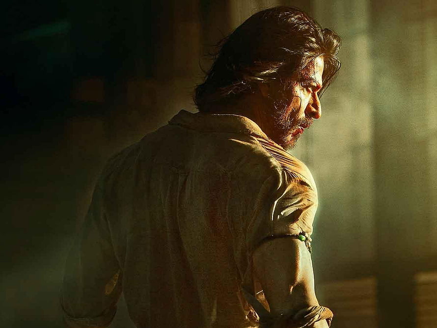 Shah Rukh Khan in intense dramatic profile with bloodied face and torn shirt in dimly lit cinematic scene HD wallpaper