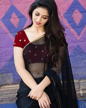 Priyanka Jawalkar in a maroon and black saree with gold embroidery against a geometric wall HD phone wallpaper