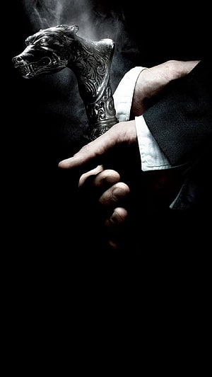 Hand Gripping Ornate Silver Lion Head Cane Handle in Dramatic Dark Lighting HD phone wallpaper