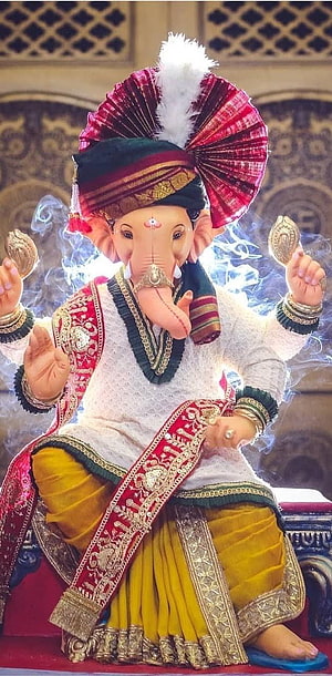 Ornate Ganesha Murti in Traditional Attire with Elaborate Headdress and Gold Jewelry HD phone wallpaper