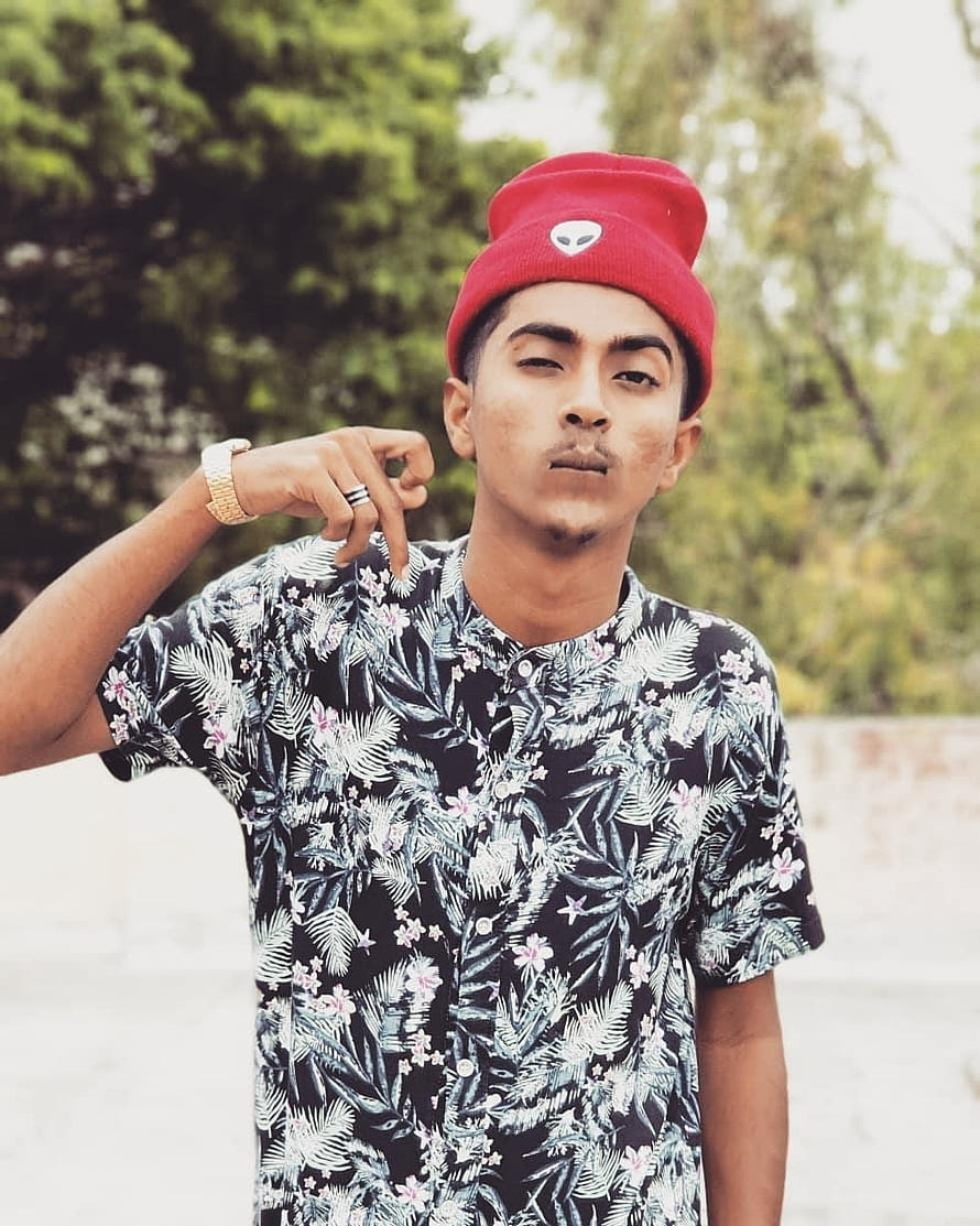 MC Stan Rapper Wearing Red Beanie and Floral Shirt in Outdoor Portrait HD phone wallpaper