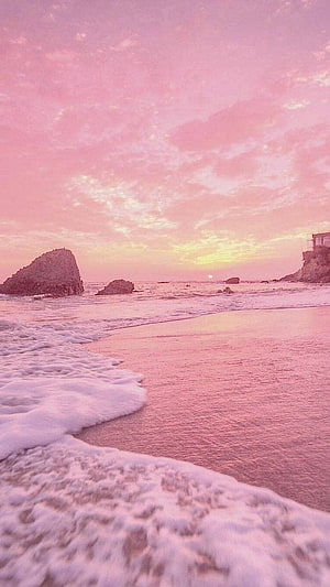 Pink Sunset Beach with Rocky Outcrops and Gentle Waves HD phone wallpaper