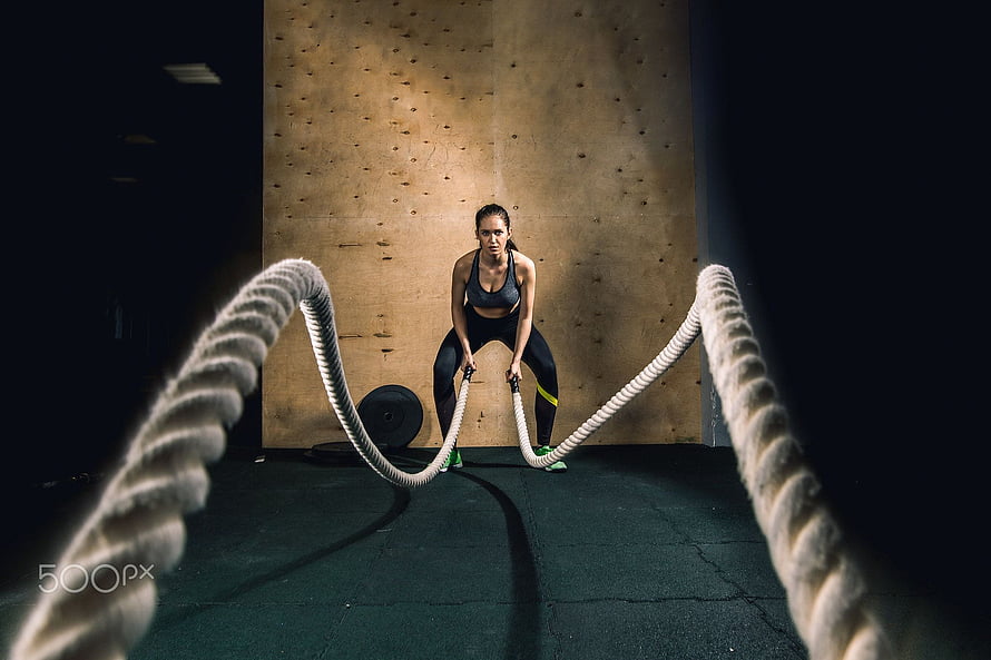 Athletic Woman Performing Battle Rope Workout in Dark Gym Setting, battling ropes girl at gym workout exercise fitted body, women battle rope HD wallpaper