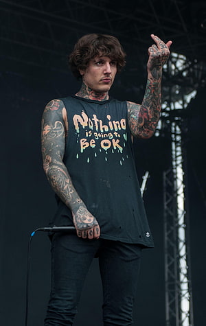 Oli Sykes of Bring Me The Horizon performing live on stage with full sleeve tattoos HD phone wallpaper