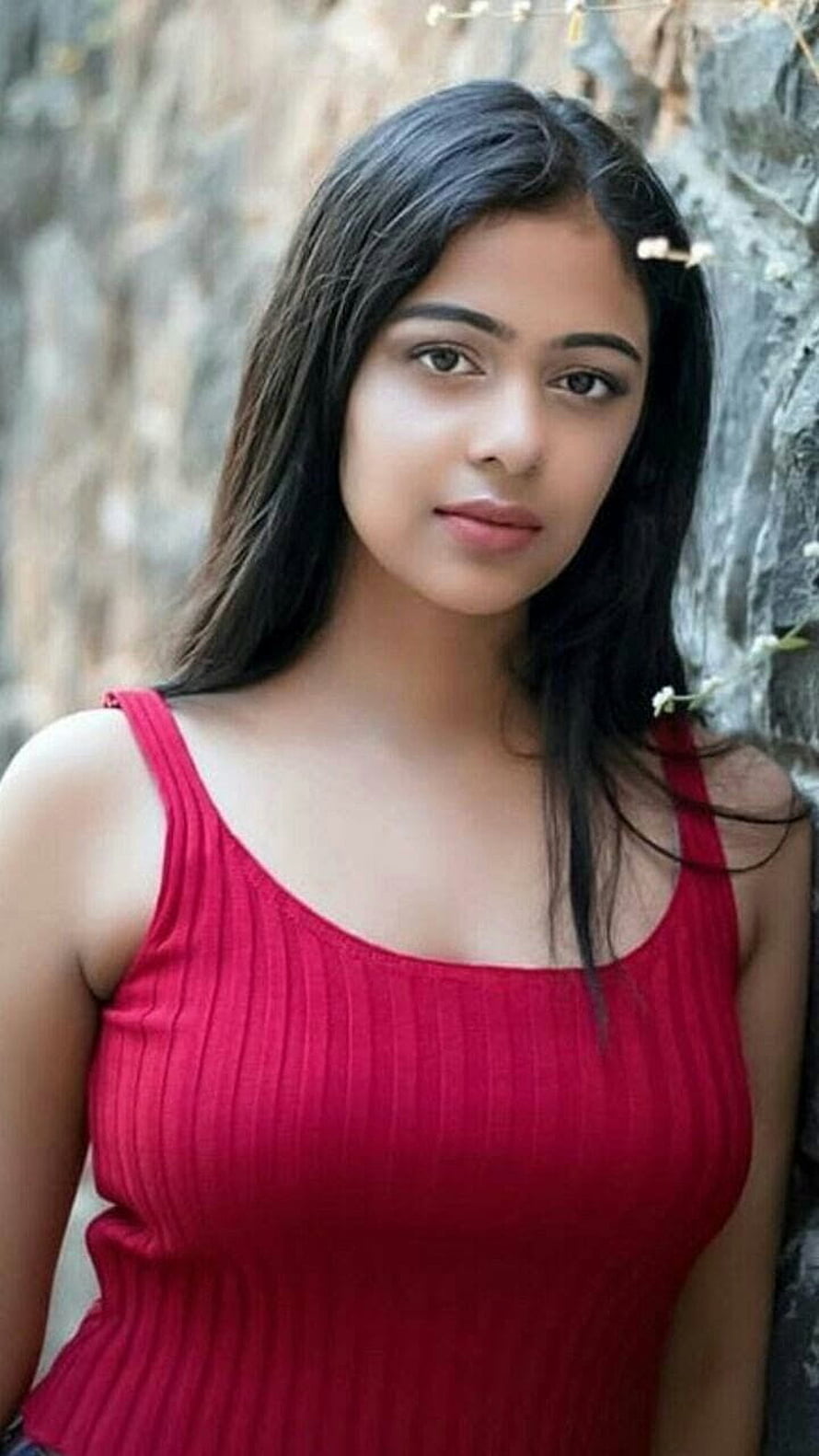 Young woman in red ribbed tank top posing against a textured stone wall, beautiful girl indian, instagram girls dp HD phone wallpaper