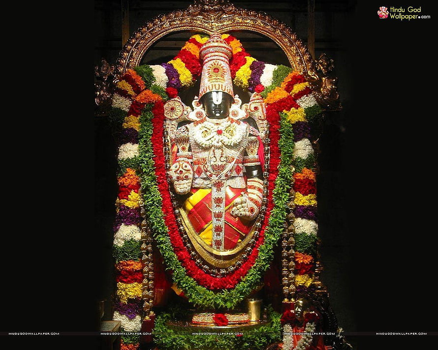 Lord Ayyappa adorned with vibrant flower garlands and golden ornaments in a temple shrine HD wallpaper