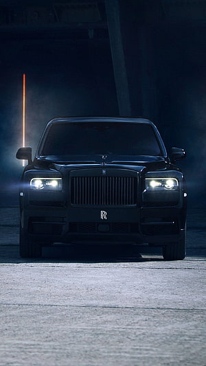 Black Rolls Royce Cullinan Front View in Dark Industrial Setting with Glowing Headlights HD phone wallpaper