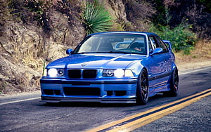 Blue BMW E36 M3 Coupe Driving on a Winding Mountain Road with Custom Body Kit HD wallpaper