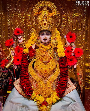 Goddess Durga adorned in gold jewelry and red flowers HD phone wallpaper