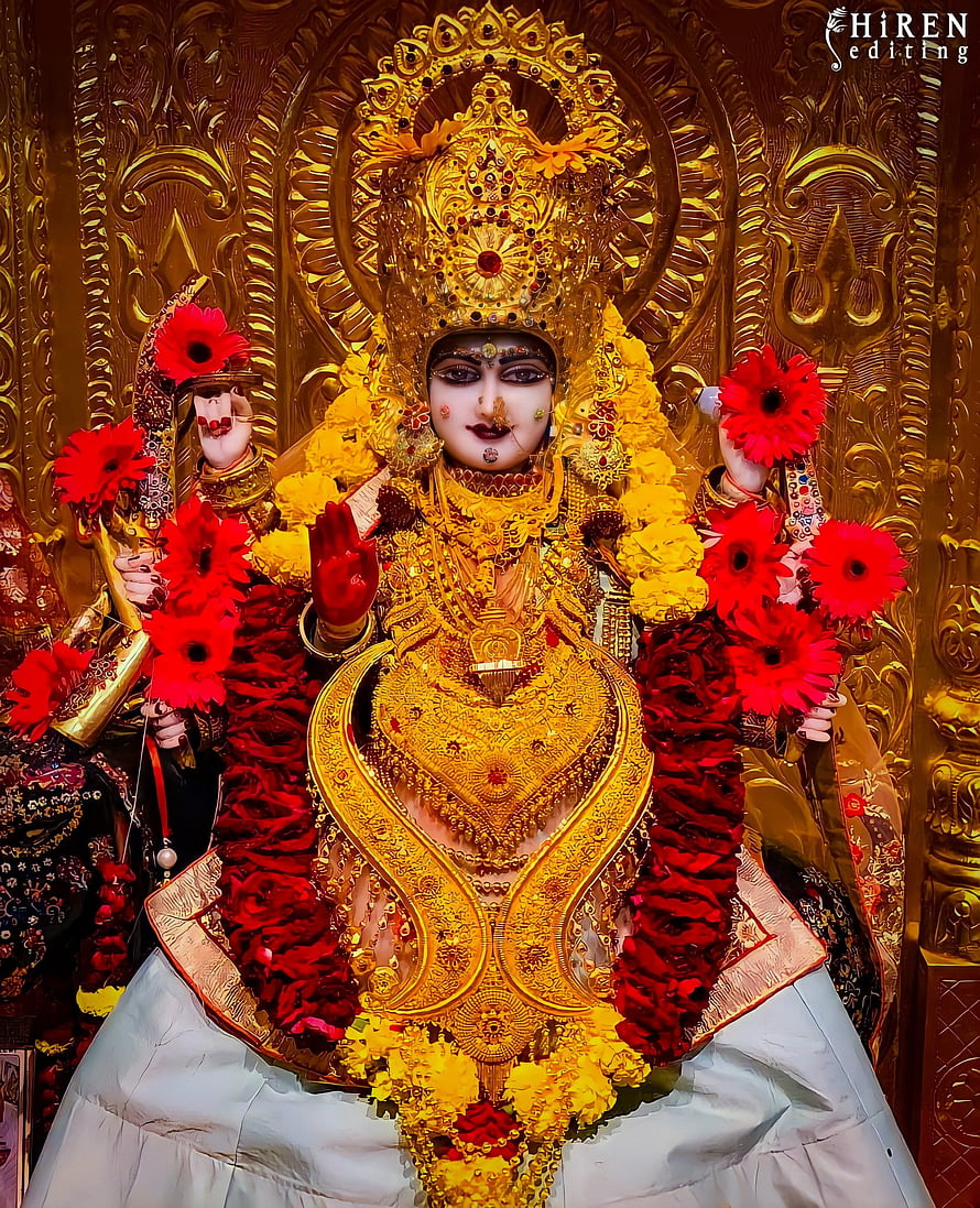 Goddess Durga adorned in gold jewelry and red flowers HD phone wallpaper