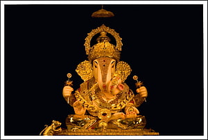 Golden Ganesha Statue with Intricate Jewelry and Crown on Black Background HD wallpaper