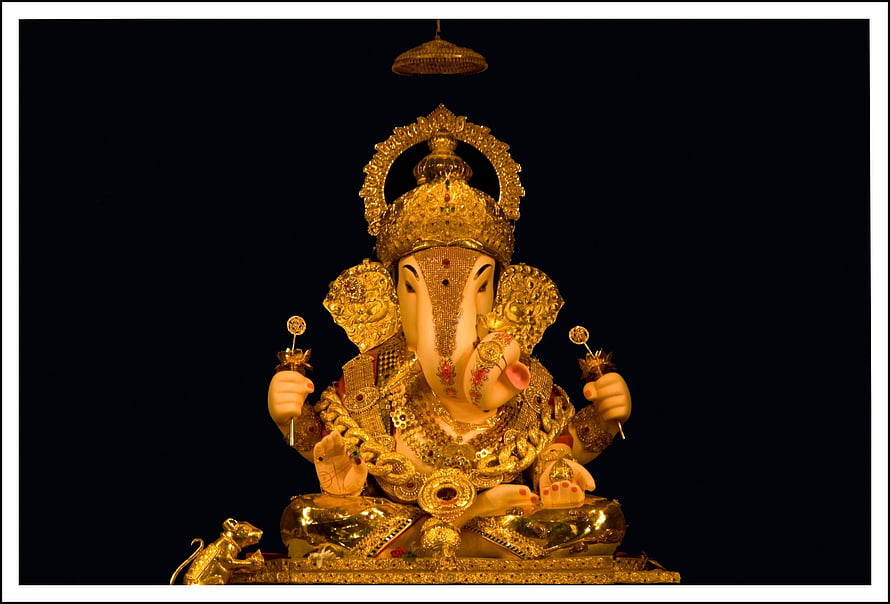 Golden Ganesha Statue with Intricate Jewelry and Crown on Black Background HD wallpaper