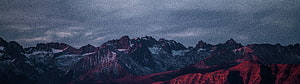 Dramatic Alpine Mountain Range at Dusk with Snow-Capped Peaks and Moody Sky HD wallpaper