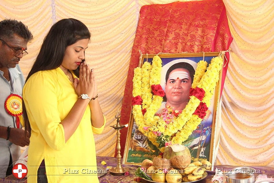 Woman in yellow offering prayers at a memorial altar with floral garlands and fruit offerings, Pasumpon Thevar, muthuramalingam HD wallpaper