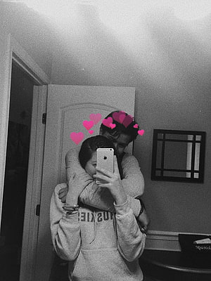 Black and white mirror selfie of a couple embracing with pink heart stickers HD phone wallpaper