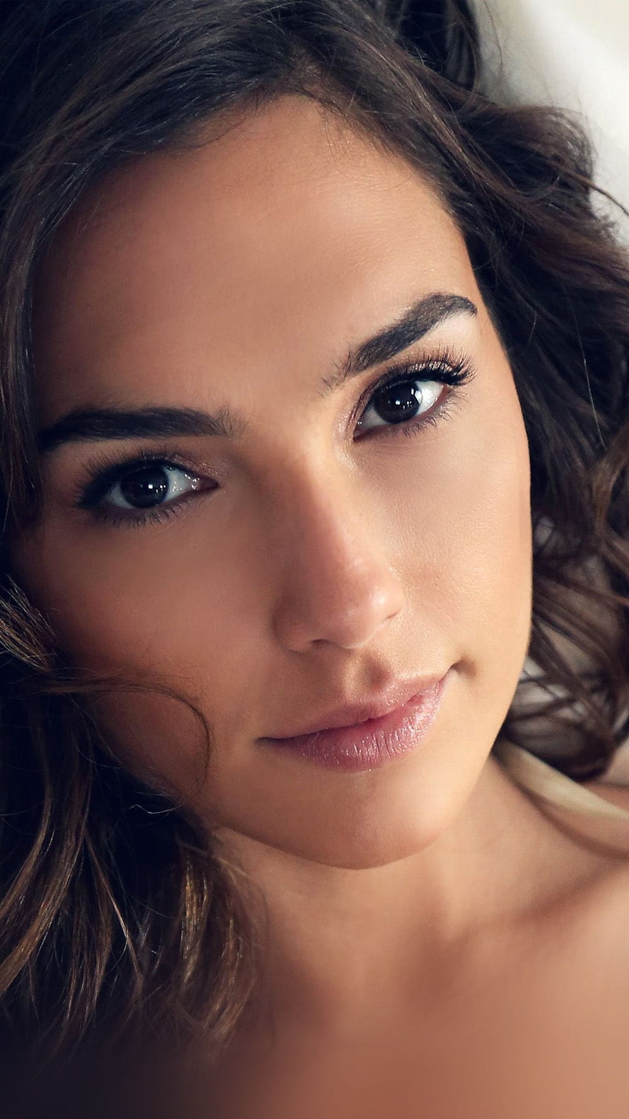 Gal Gadot Close-Up Portrait with Dark Wavy Hair and Soft Natural Lighting HD phone wallpaper