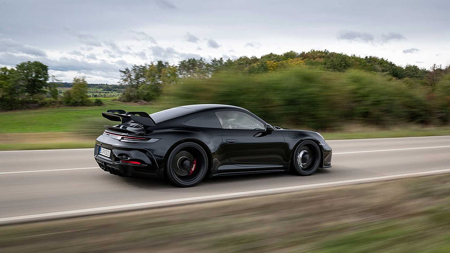 Black Porsche 911 GT3 RS speeding on a country road with motion blur HD wallpaper