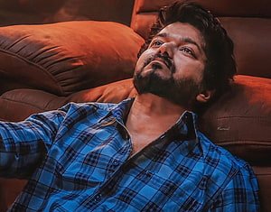 Vishal Vishal in Blue Plaid Shirt Lying on Brown Sofa HD wallpaper