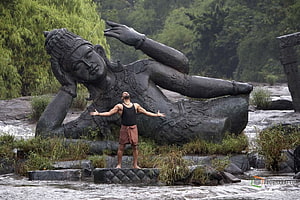 Man standing with arms outstretched before giant reclining statue in river, Raavanan Stills and , & Moviestills, #raavanan HD wallpaper