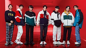 BTS members wearing FILA sportswear in a vibrant red studio setting HD wallpaper