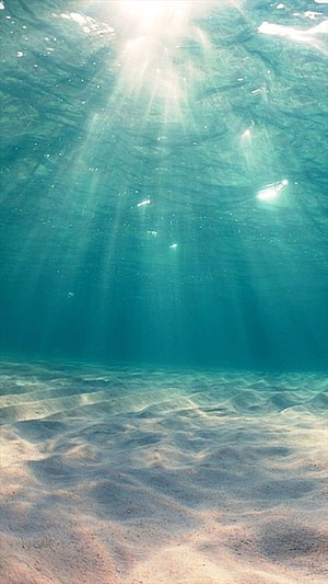 Sunlight Rays Penetrating Clear Turquoise Ocean Water Over Sandy Sea Floor HD phone wallpaper