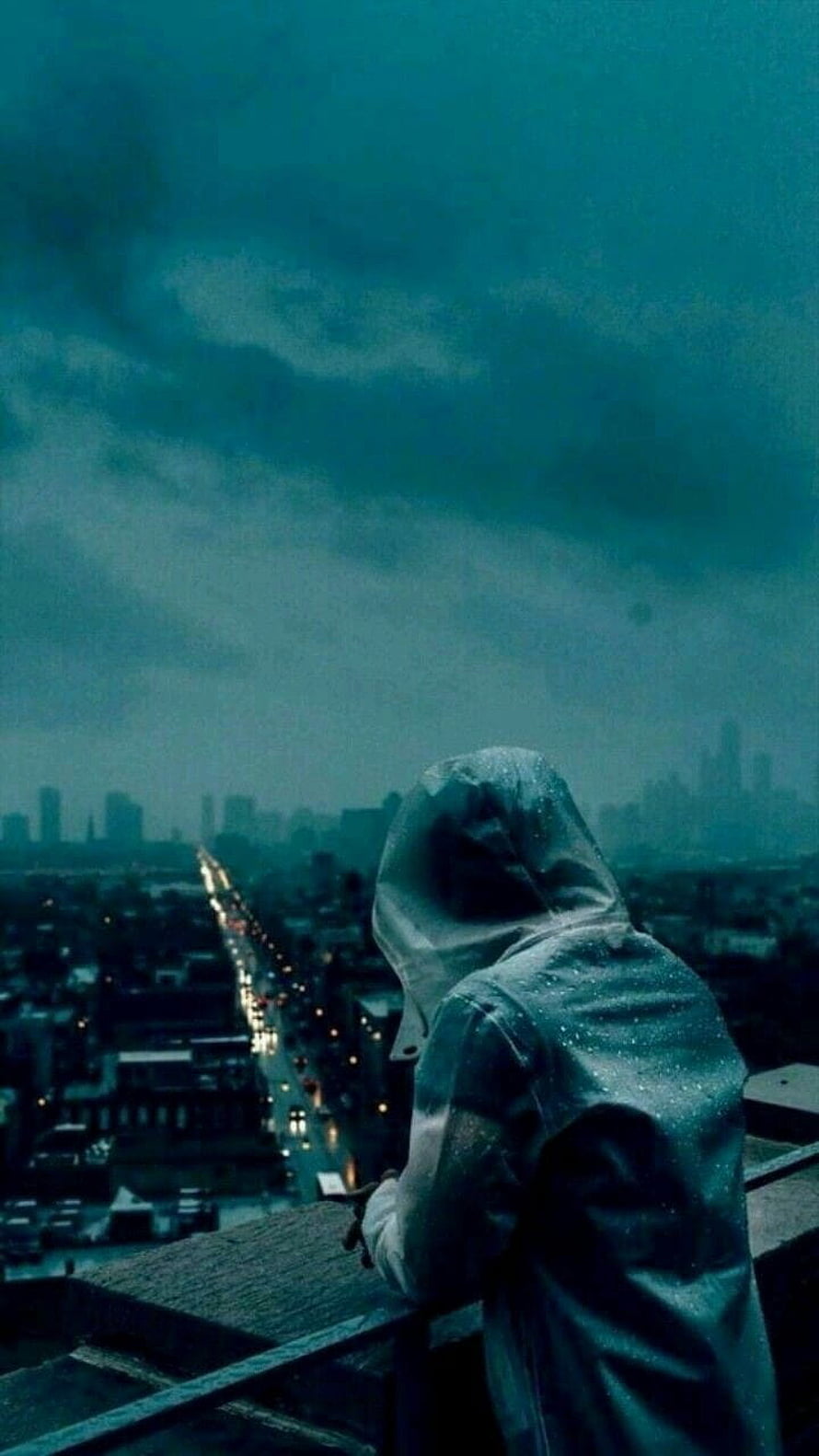 Hooded Figure Overlooking Rainy City Skyline at Night HD phone wallpaper